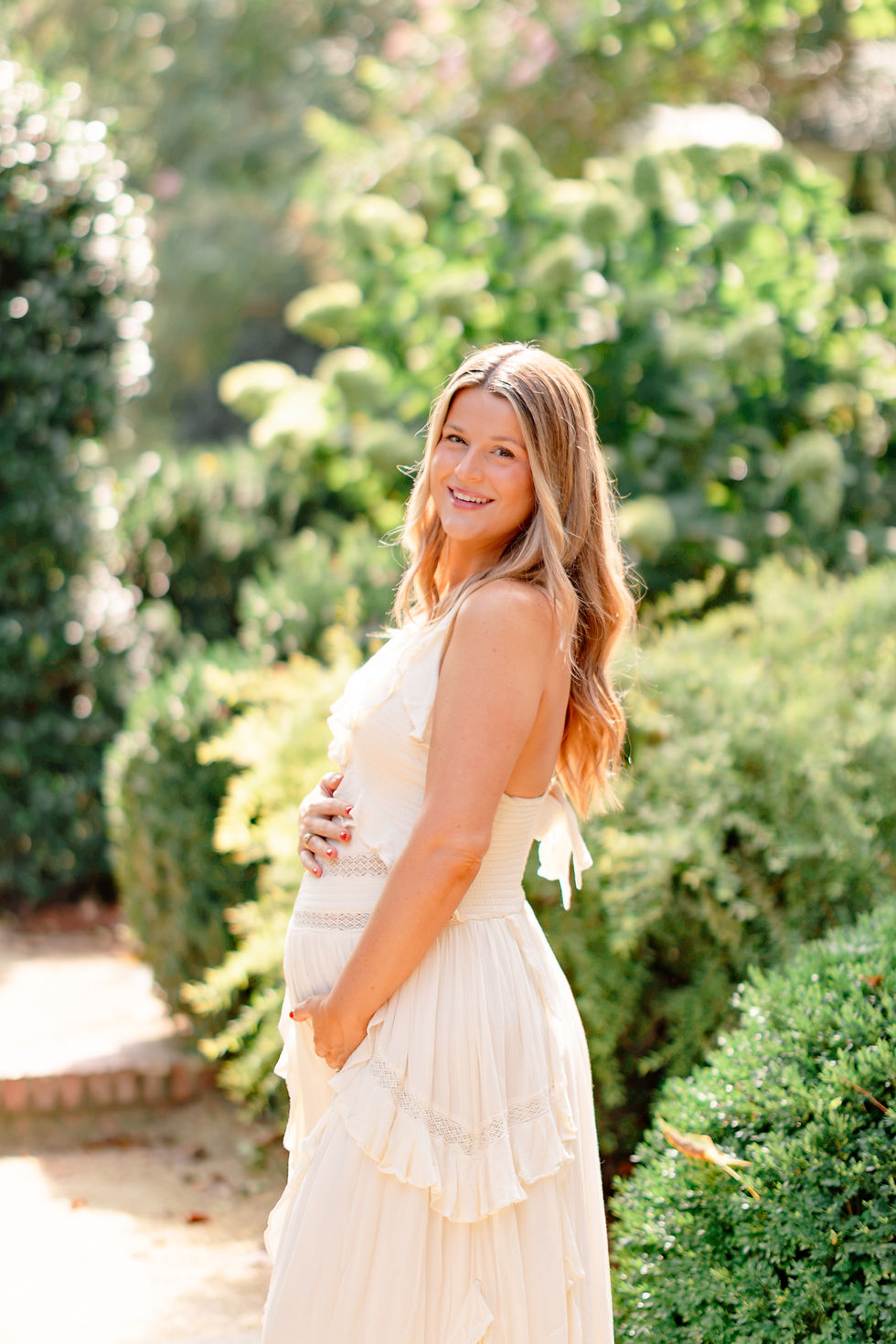 Garden maternity portrait in an ivory dress at The Duke Mansion in Myers Park Charlotte NC