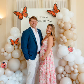 Expecting parents at the A Little Love Bug balloon backdrop at their Duke Mansion baby shower in Charlotte, NC