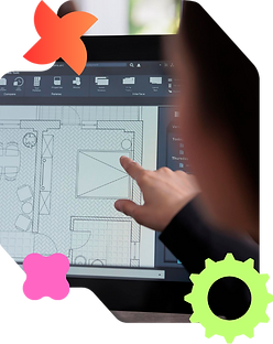 An interior designer or CAD technician pointing at a 2D architectural floor plan layout displayed on a computer screen, reviewing furniture placement and technical details.