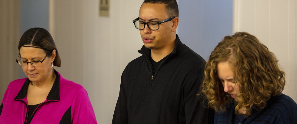 Paztuh Mike and Anna praying together with another woman on the left side of them praying as well. 