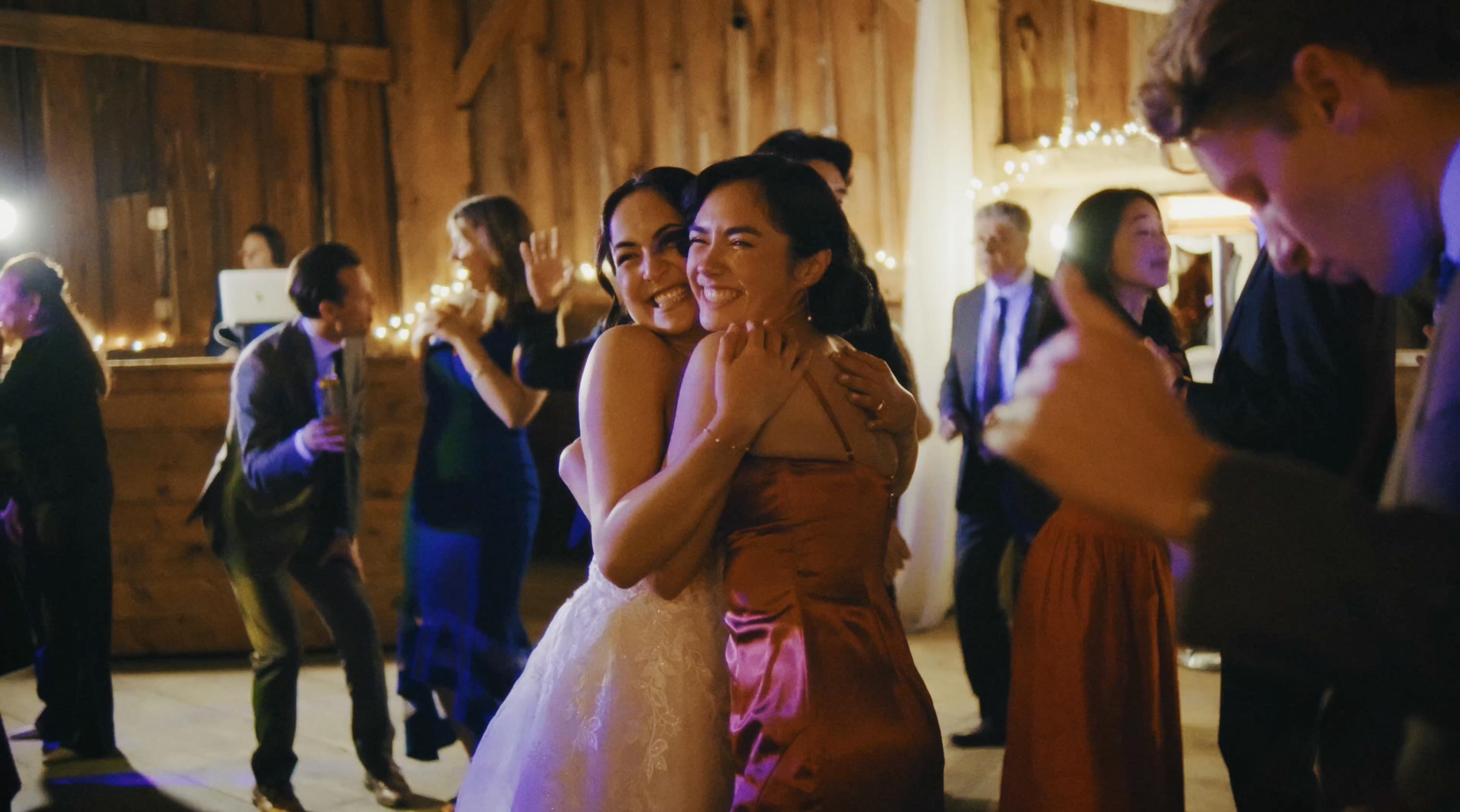 Wedding videography capturing guests and newlyweds dancing at the reception