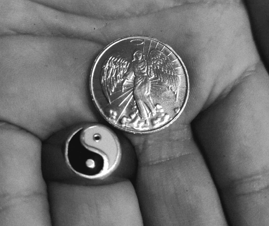 Coin and a ring in someone's hand.