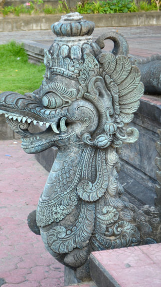 Intricately carved stone dragon statue with ornate details, set against a grassy and stone path background, exuding an ancient, mythical vibe.