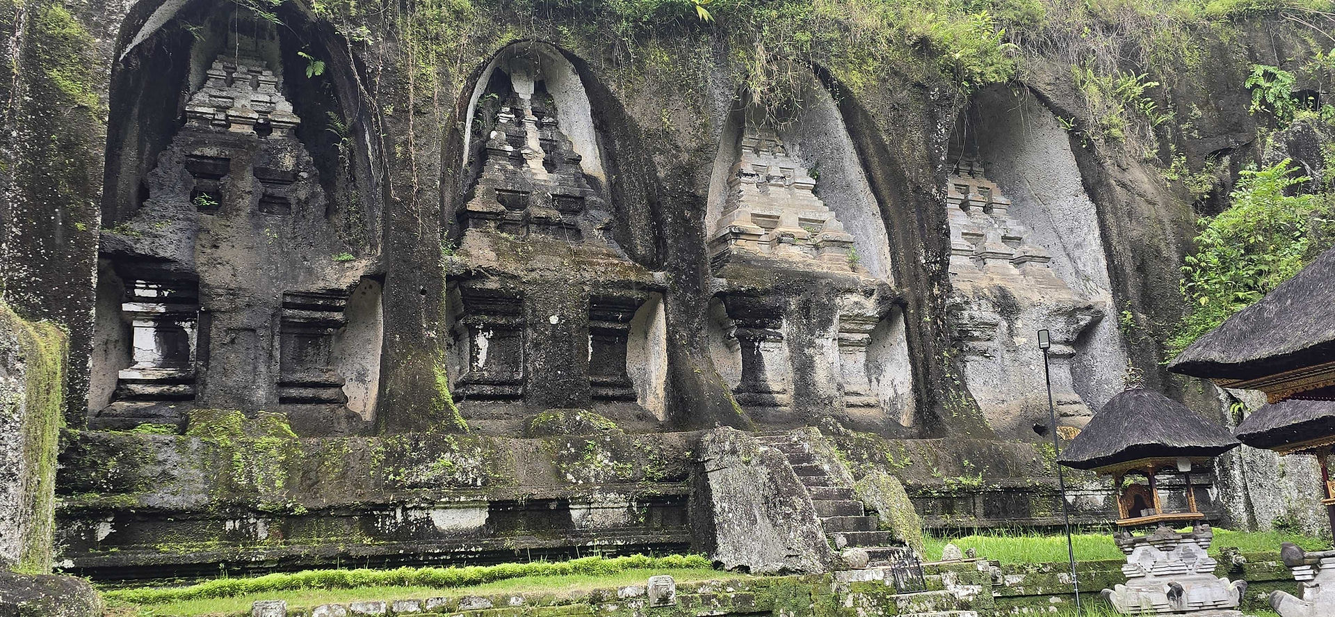 The stunning Gunung Kawi Tampaksiring temple complex in Bali, showcasing stone tombs and statues set against the serene landscape