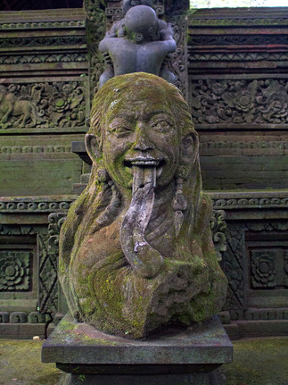 mossy Stone leyak statue snarling at the front of a Balinese temple