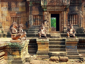 Ancient temple with intricate stone carvings and four monkey statues. Warm hues, detailed patterns, sunny day, and a serene mood.
