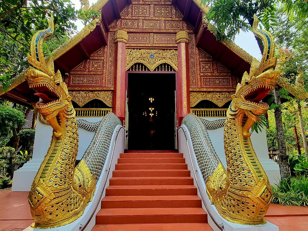Ornate temple with gold dragon sculptures flanking red steps. Detailed carvings and greenery surround the entrance, evoking a serene mood.