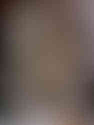 Ancient stone statue of a meditating figure with a naga serpent backdrop. Golden patina highlights create a serene, spiritual atmosphere.