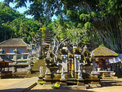 Wide-angle view of Pura Kehen's inner courtyard, featuring tiered Meru shrines and a towering banyan tree at the centre