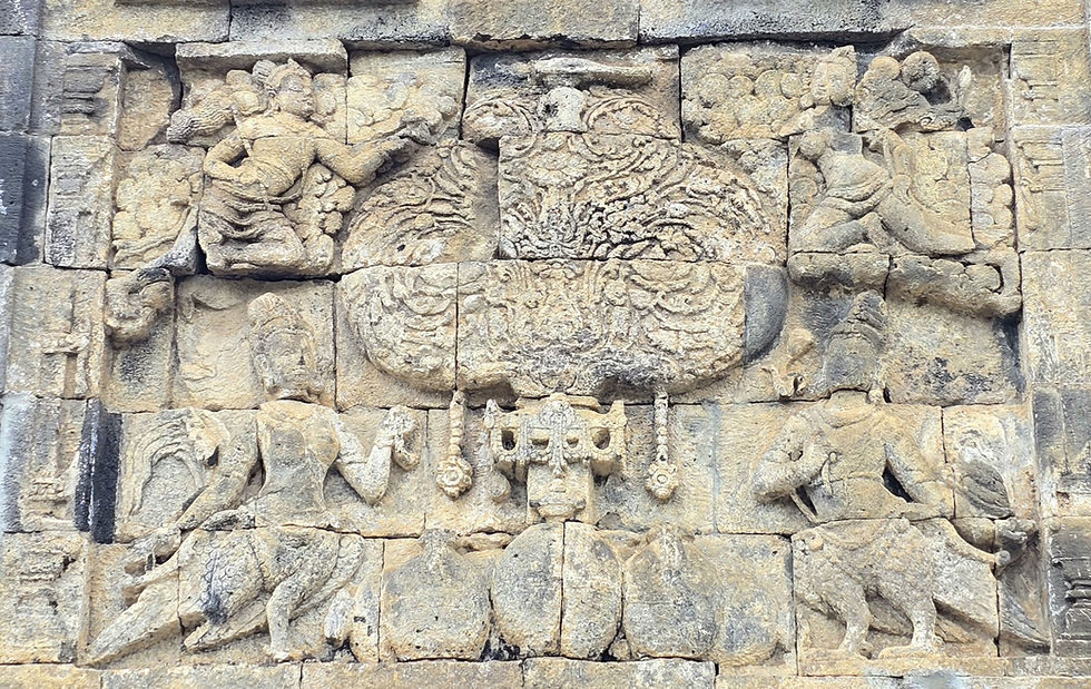 Ancient stone carving depicting figures, an intricate design, and a peacock, set on a textured wall. Neutral stone colors.