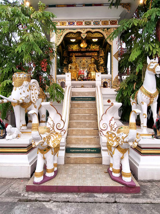 narrow staircase up to main temple, decorative with green trees on either side