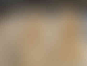 Ancient stone relief with seated and standing figures under a tree, detailed carvings on textured tan surface, giving a serene atmosphere.