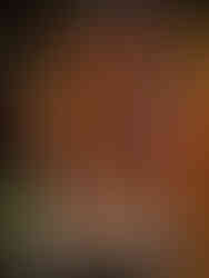 Vibrant colourful lanterns with intricate patterns hang in a warmly lit outdoor market setting, creating a festive atmosphere at night.