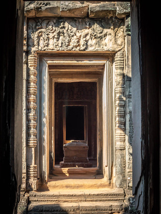 View of a dimly lit sanctuary chamber, with vaulted ceilings supported by thick stone columns, and soft shafts of light