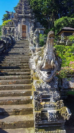 View of the 38 steep stone steps leading up to Pura Kehen Temple, flanked by intricately carved guardian statues from the Ramayan