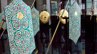 ornate green, gold and red shields, glossy black tiled floor
