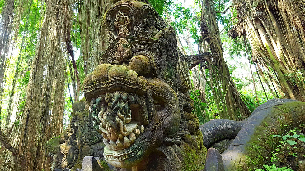 Ancient stone serpent statue with intricate carvings in a lush jungle setting, surrounded by dense green foliage and hanging tree roots.