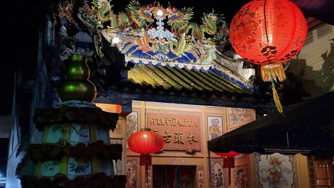 Colourful temple entryway lit up at night, red glowing lanterns