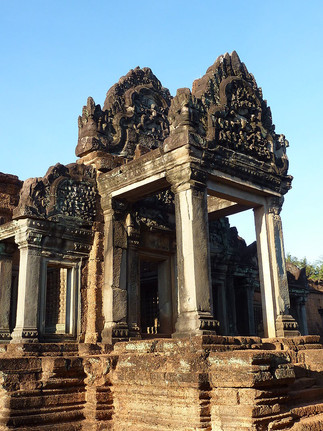 Grand doorway with pillars, ornate lintel, bright blue sky