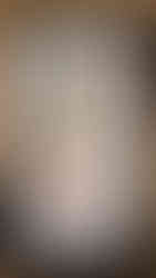 Shadow puppet with intricate design and vibrant colors framed in black, set against a wooden background.