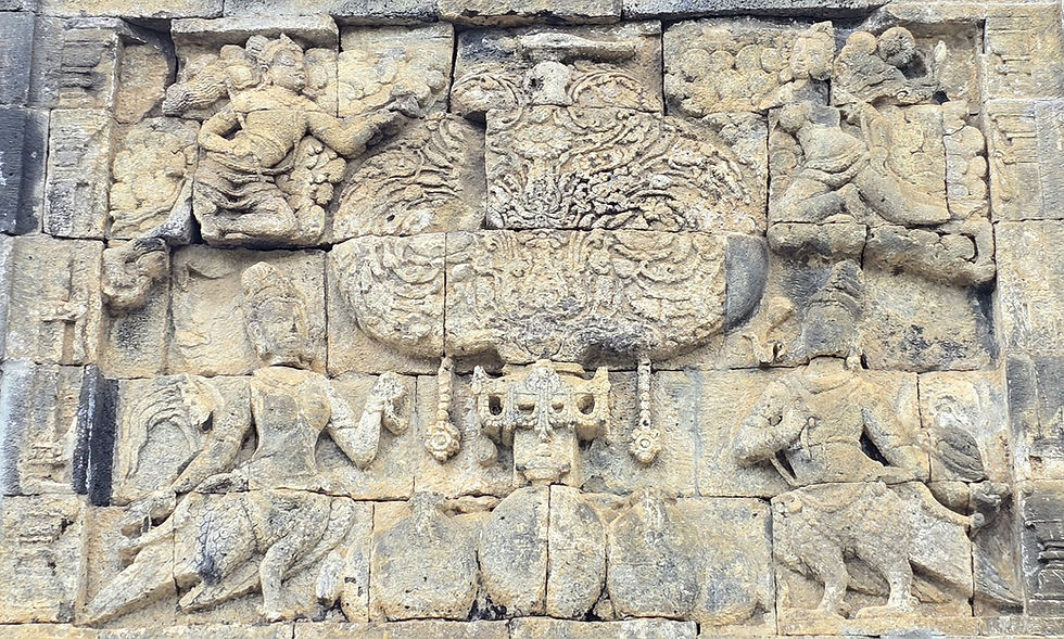 Ancient stone relief depicting intricate carvings of figures and patterns, featuring mythical winged creatures, set against a weathered temple wall.