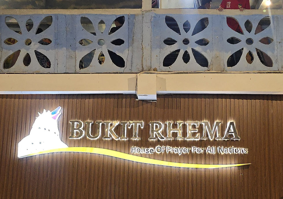 Bukit Rhema sign with glowing text, "House Of Prayer For All Nations," on wood panel. Decorative concrete with cut-out patterns above.