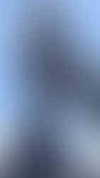 Ornate statue of a deity with elaborate headdress and flowing fabric, set against a clear blue sky, exuding grace and majesty.