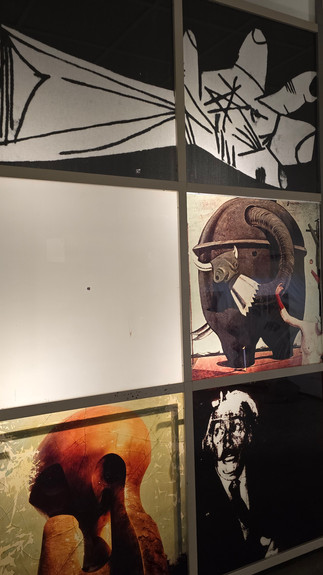 Art display with four panels: abstract hand-drawn lines, a bull with a horn, an orange-hued embracing figure, and a monochrome man. Dim lighting.