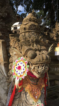 Ornate stone sculpture of a mythical creature adorned with colorful decorations and patterns in a traditional temple setting. Bright, intricate details.