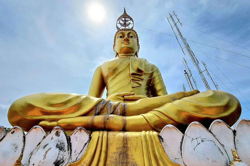 Golden Buddha statue in a meditative pose, set against a blue sky with antennas in the background. Sun shines above, creating a serene mood.