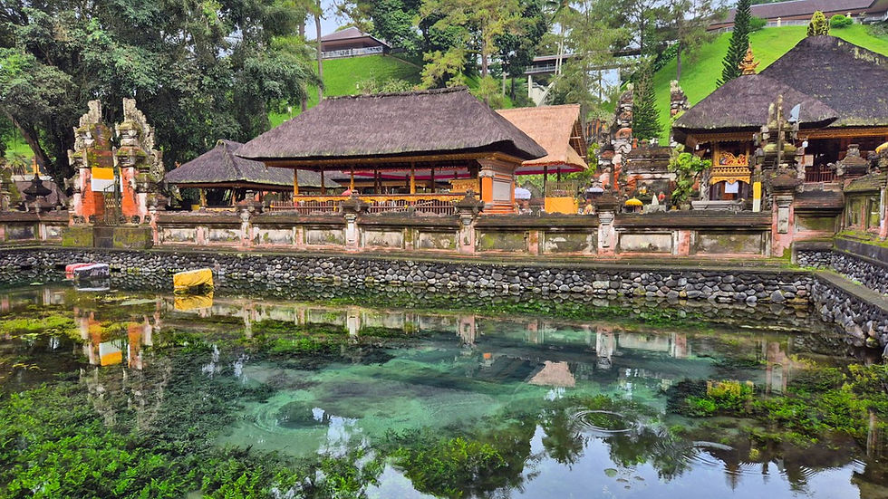 Temple with thatched roofs surrounded by lush greenery and a clear pond reflecting the vibrant landscape, creating a serene atmosphere.