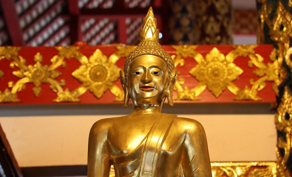 A golden Buddha statue with ornate patterns, set against a decorative red and gold background, creating a serene and elegant ambiance.