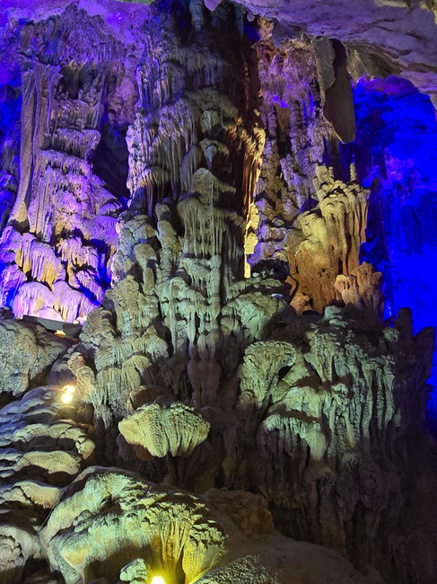 Coral looking stalagmites in pastel yellow, pink and warm artificial light