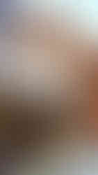 Colourful street with Asian architecture, red lanterns, and vibrant signs. Shops have greenery and a "COCONUT" sign is visible. Bright atmosphere.