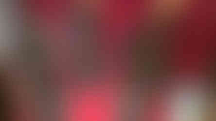 Ornate daggers displayed on stands against a red background in a glass case. A QR code plaque is visible on the right.