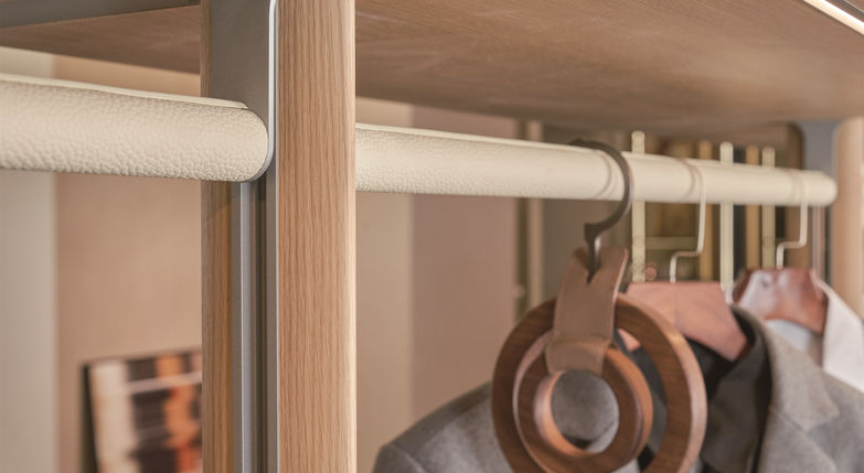 Close-up of cream leather-wrapped hanging rail with LED strip lighting on oak frame in Rack Series wardrobe, custom wardrobe by Radiant Edge Design Singapore