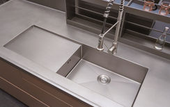 Integrated stainless steel sink basin with countertop close-up, custom kitchen cabinet by Radiant Edge Design