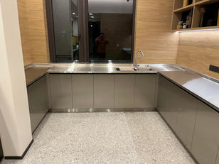 Completed U-shaped stainless steel kitchen with brushed countertops, gunmetal flat-door cabinets and integrated sink, installed by Radiant Edge Design Singapore