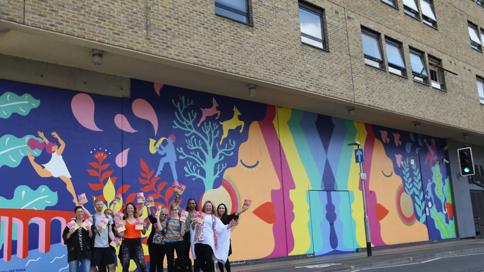 Group of people from the community in front of the Zoe Power mural in Ipswich