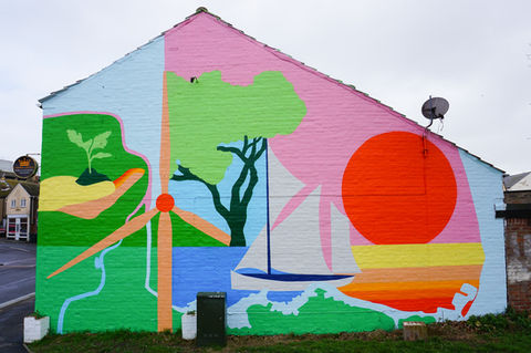 Rights Community Action commissioned two murals in Lowestoft as part of the We Are Here campaign to encourage community resilience to the climate emergency. Art Eat selected artists from Bud Studio who worked with 25 community participants to develop the design which is a depiction of Lowestoft and illustrates all the positive action happening in terms of climate, such as wind energy. It is also a map of the area and works to illustrate the vibrance of the environment and also encourages tree planting and protection of the landscape. 