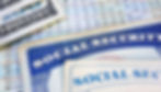 Tarjetas del Seguro Social junto a documentos con números y billetes de dinero sobre una superficie.