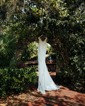 wedding dress hangs from ivy archway