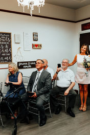 friends and family sit and watch a bride and groom's courthouse wedding ceremony.