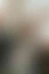 a photo of a bride smiling while mid conversation as she is surrounded by family and friends.