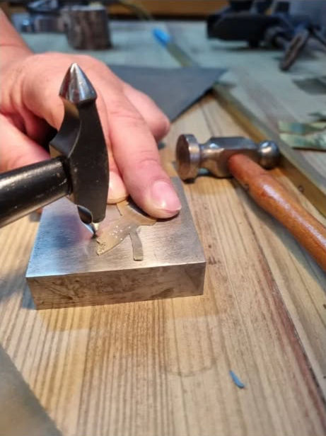 ידיים עובדות על שולחן עץ בתהליך צורפות