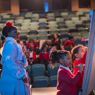 woman with children on stage, drawing game