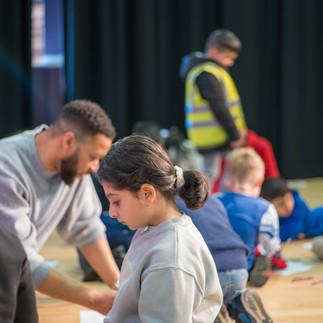 man and children drawing on paper