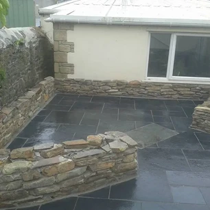 Slate stone slabs laid and specialist traditional curved stone wall built in front of hous