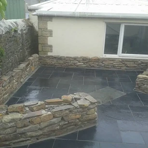 Slate stone slabs laid and specialist traditional curved stone wall built in front of hous