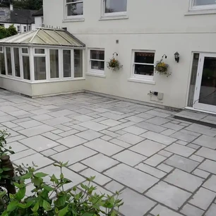 Light stone slabs laid for external patio space.webp